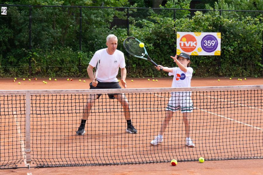 Volwassene en kind spelen samen aan het net op de gravelbanen van TV De Kegel in Amstelveen — 359.tennis