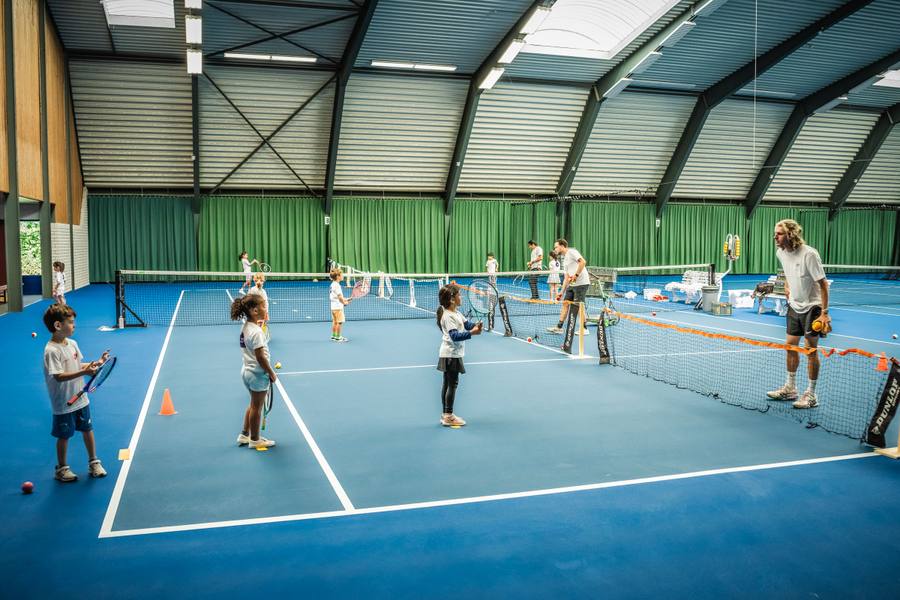 Kinderen bewegen en spelen tijdens een indoor beginnerstennisles op NTC Amstelveen — 359.tennis