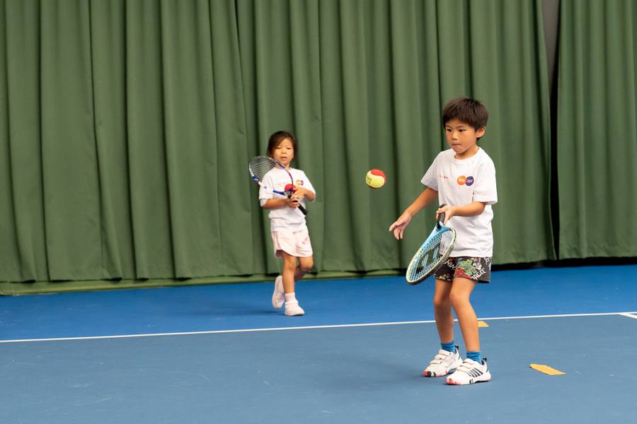 Twee kinderen spelen een rally tijdens een indoor tennisles in Amstelveen — 359.tennis