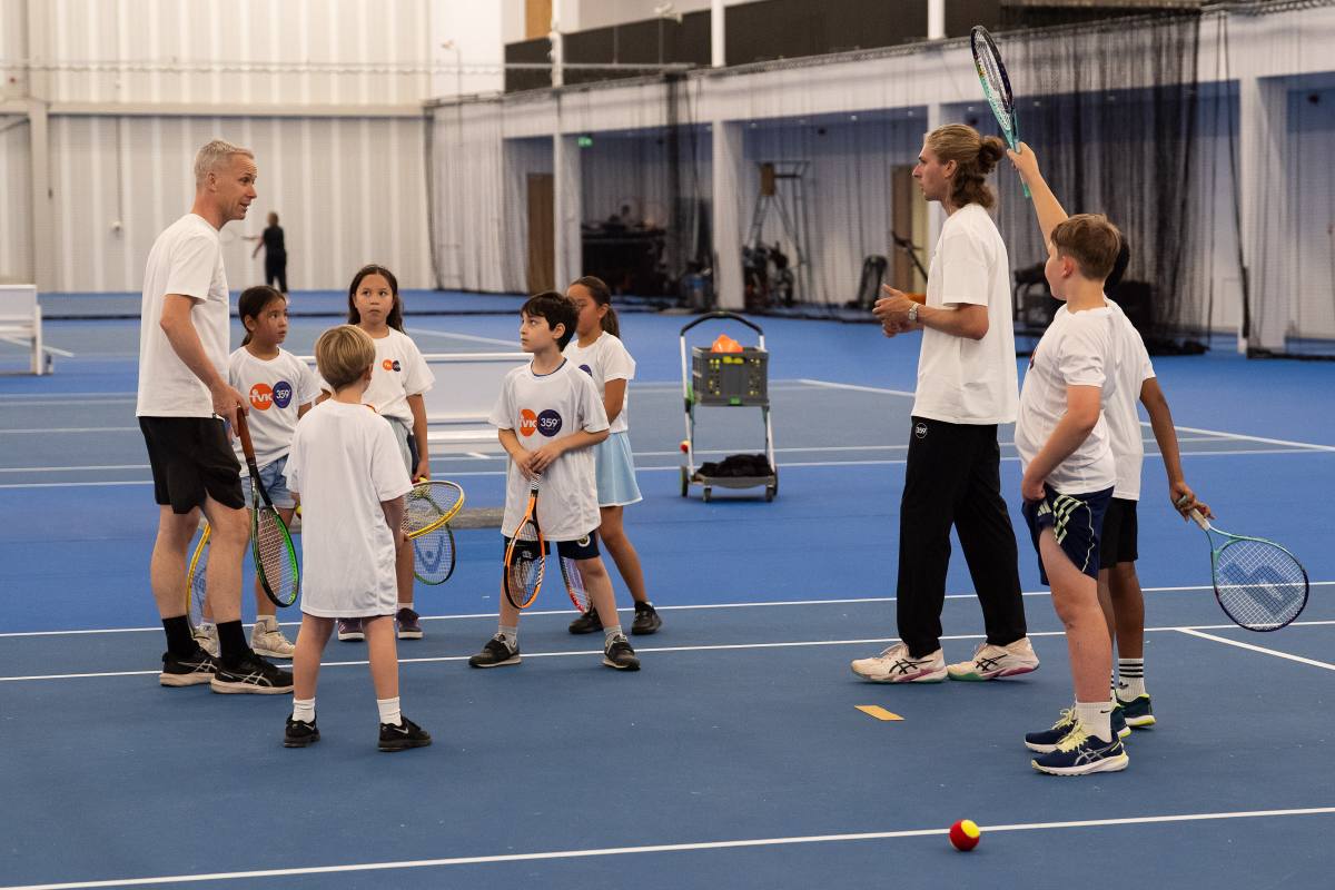Groep spelers en coaches tijdens een indoor tennisles bij 359.tennis op NTC Amstelveen